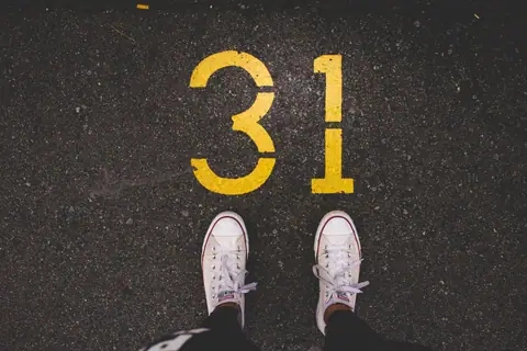 White sneakers on asphalt (Unsplash)