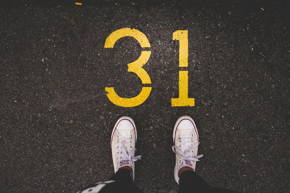 White sneakers on asphalt (Unsplash)